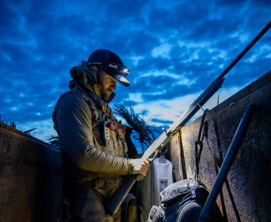 A hunter using a Fenix headlamp to prepare for hunting