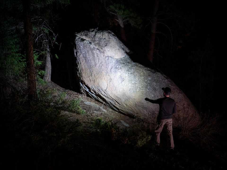 A sturdy Fenix flashlight illuminating a dark path, symbolizing reliability and high performance.